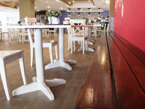 a white table and chairs in a restaurant at Hotel Corona Plaza in Rosarito