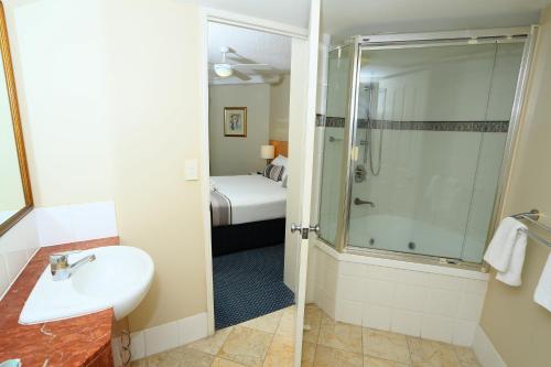a bathroom with a shower, sink, and toilet at Landmark Resort in Mooloolaba