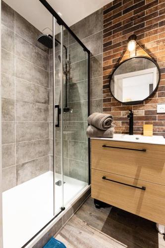 une salle de bain avec une douche, un lavabo et un miroir dans l'établissement Au cœur du Vieux Port - Le quai bourgeois, à Marseille