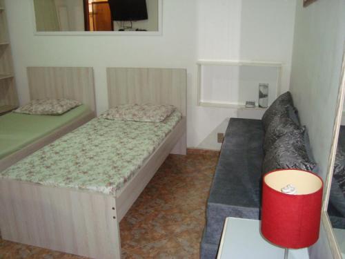 um pequeno quarto com 2 camas e um sofá em Apart Marcelo - Studio Copacabana no Rio de Janeiro