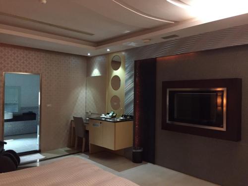 a hotel room with a bed and a television at Chateau Motel & Spa in Kaohsiung