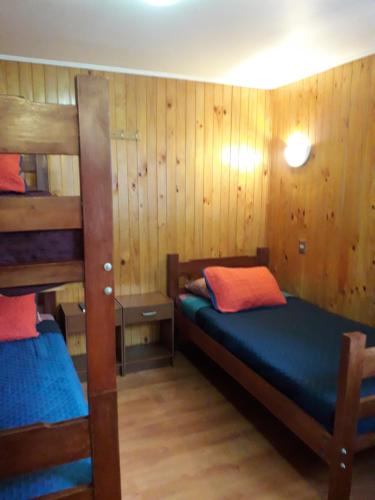 2 literas en una habitación con paredes de madera en Apart-Hotel Colonia-Königsberg ESTACIONAMIENTO Deptos Completos Ubicado En El Centro De Valdivia AIRE ACONDICIONADO en Valdivia