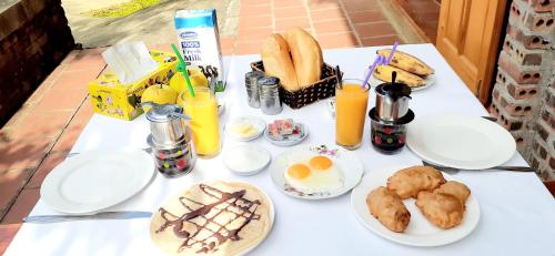 a white table topped with plates of food and drinks at Sa House Bac Ha in Bắc Hà