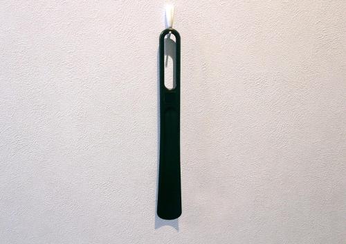 a black candle on a white wall at Hotel Sports Palko in Gifu