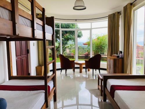 a room with two bunk beds and a table and chairs at The Heaven's Villa Kandy in Kandy