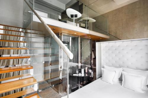 a bedroom with a white bed and a staircase at M Social Singapore in Singapore