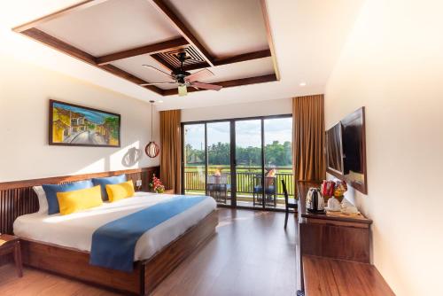 a bedroom with a large bed and a television at Eden Hoi An Villas in Hoi An