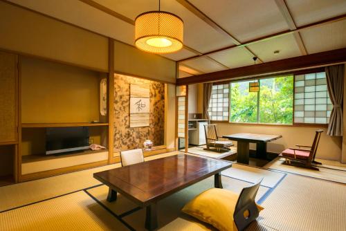 a living room with a table and a television at Kagiya in Minamiizu
