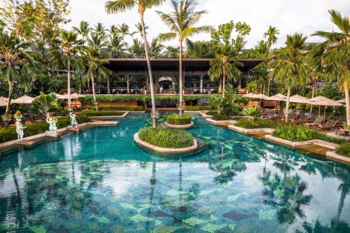 einen Pool in einem Resort mit Palmen und Sonnenschirmen in der Unterkunft Anantara Bophut Koh Samui Resort in Bophut 