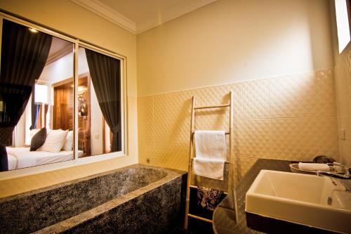 RaVorn Villa Boutique في باتامبانغ: حمام مع حوض ومرآة