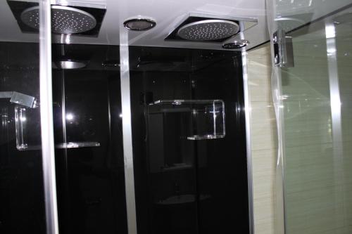 a bathroom with a black shower and a mirror at Meka Hotel in Dragash