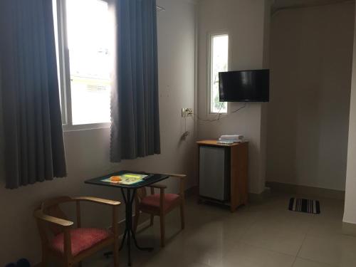 a room with a table and chairs and a television at PHUC LONG 2 HOTEL in Can Tho