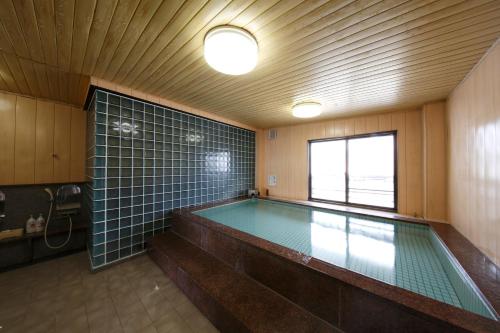 a swimming pool in a room with a large window at Masunoi in Mie