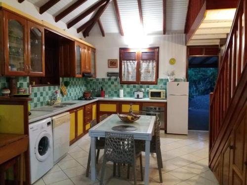 eine Küche mit einem Tisch in der Mitte in der Unterkunft Villa Ponm Kann'L in Deshaies