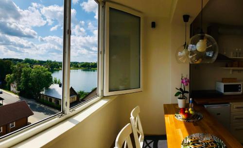 a kitchen with a large window with a view of a lake at Cozy apartment with lake view in Trakai