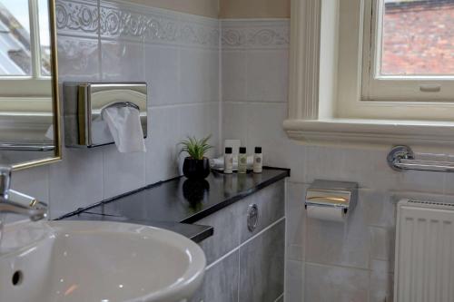 a white bathroom with a sink and a mirror at Crown & Mitre Hotel in Carlisle
