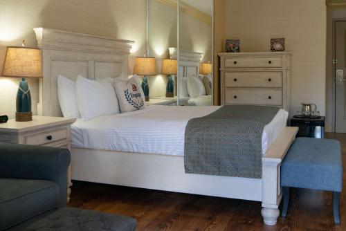 a bedroom with a large white bed and a chair at Prestige Beach House, WorldHotels Crafted in Kelowna