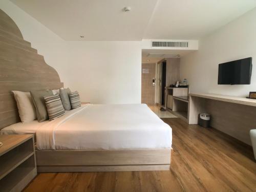 a bedroom with a large bed and a television at Methavalai Residence Hotel in Bangkok