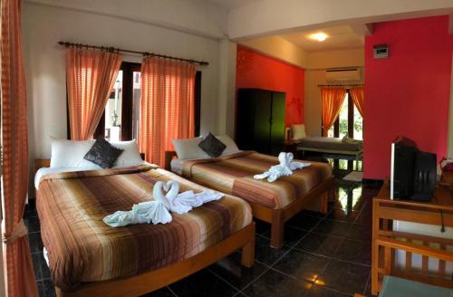 Baan Chanoknunt Resort Pai في باي: غرفه فندقيه سريرين عليها مناشف