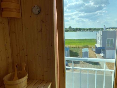 a window with a clock and a view of a lake at Schleivilla Hafenmeister in Kappeln