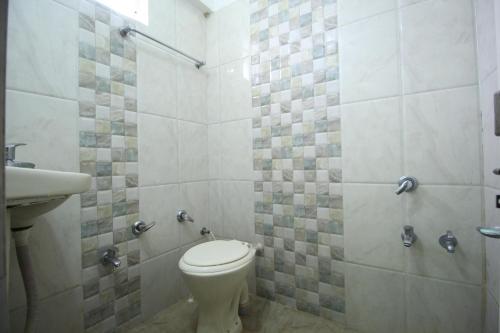 a bathroom with a toilet and a sink at Hotel Hillton Inn in Gandhinagar