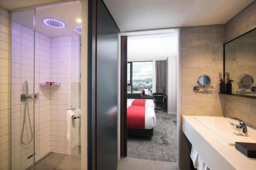 a bathroom with a shower and a bed in a room at Aiden by Best Western Cheongdam in Seoul