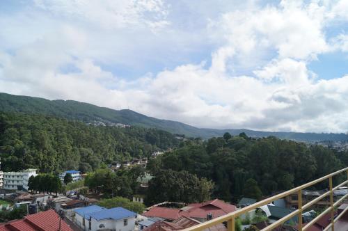 a view of a city with mountains and trees at Woodland Hill Stay in Shillong