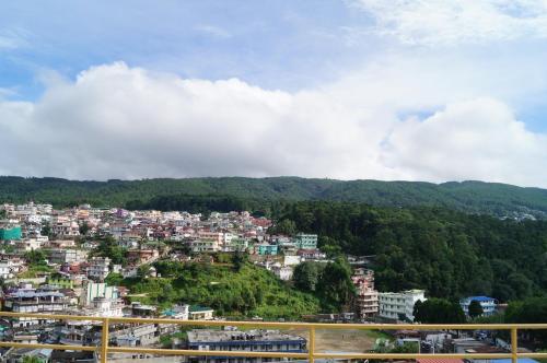 a scenic view of a city with mountains at Hotel Woodland Hill Stay in Shillong