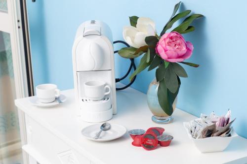 a white shelf with a bottle and a vase with a flower at Hotel Marini in Sassari