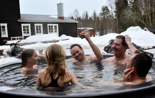 um grupo de pessoas em uma banheira de hidromassagem em Försgården Fjällpensionat em Transtrand
