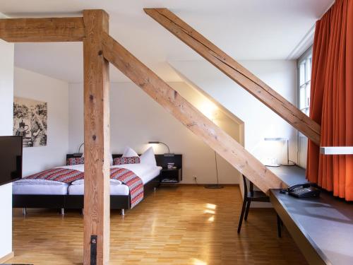 ein Schlafzimmer mit einem Bett und einem Schreibtisch in einem Zimmer in der Unterkunft Hotel Arenenberg in Salenstein