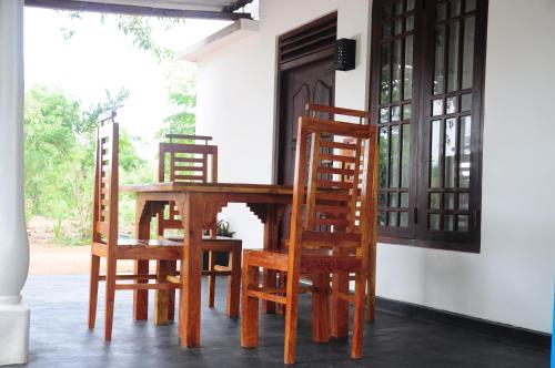 a wooden table and chairs in a room at Ceylon Resort in Wilpattu
