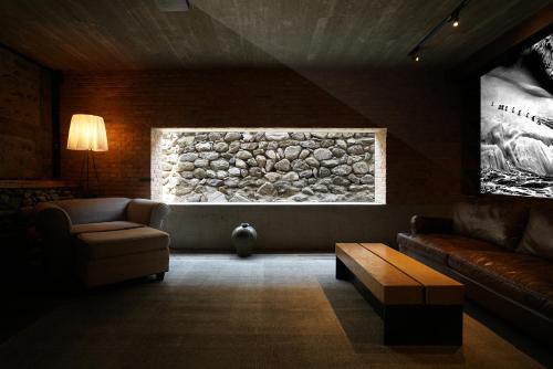 a living room with a couch and a stone wall at CMYK Stoneyards by the Great Wall in Huairou