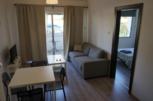 een woonkamer met een bank en een tafel bij Polyxeni Hotel Apartments in Limassol
