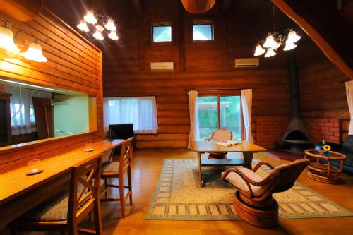 a living room with a table and chairs in a cabin at Sakura Sakura Onsen in Kirishima