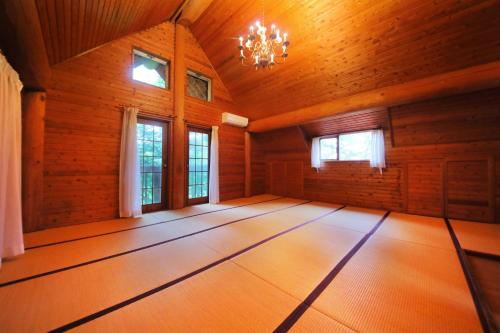 a large room with wooden walls and a chandelier at Sakura Sakura Onsen in Kirishima