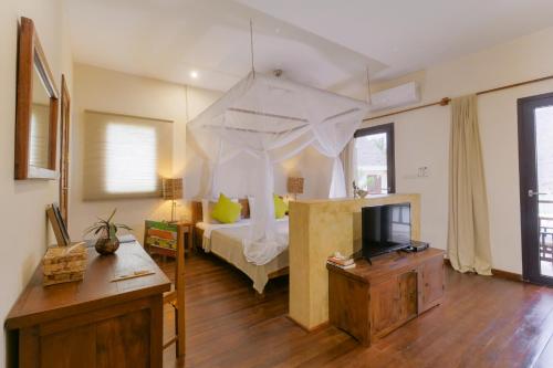 a bedroom with a bed and a tv in it at Jambiani Villas in Jambiani