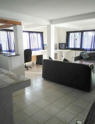 a living room with a couch and some windows at Hotel Restaurant Hellenique Appartements in Kigali