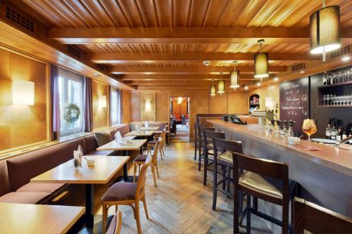 um restaurante com mesas e cadeiras e um bar em Hotel Weisses Kreuz em Feldkirch
