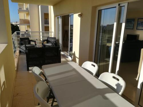 a white table and chairs on a balcony at Apartamento Vila Marachique in Alvor