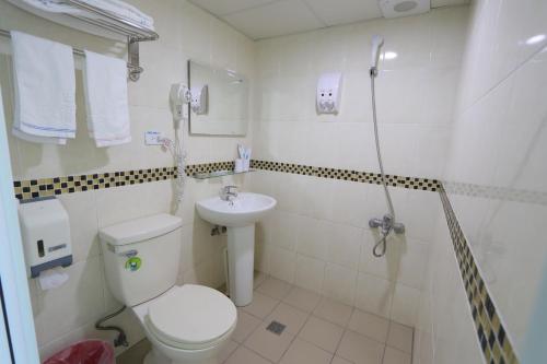 uma casa de banho com um WC, um lavatório e um chuveiro em Yi Dian Yuan Hotel em Zhongli