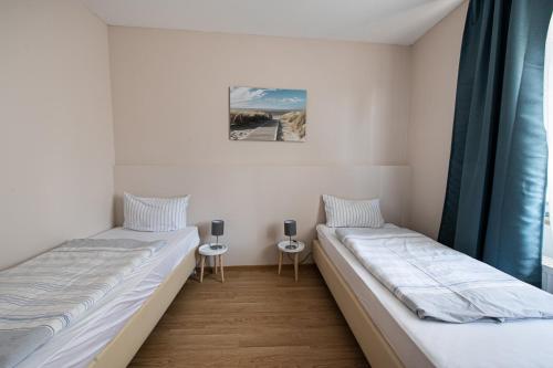 鲍纳塔尔SOVA Pension Baunatal的一间卧室设有两张床和窗户。