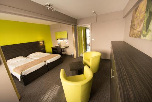 a hotel room with a bed and a chair at Ostend Hotel in Ostend