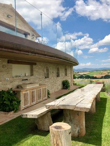 a large wooden bench in front of a building at Tenuta dei Mori-Wine Relais Events in Villanova