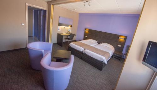 a hotel room with a bed and a television at Ostend Hotel in Ostend