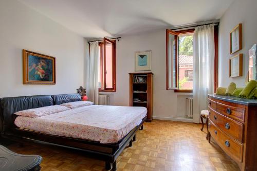 - une chambre avec un lit, une commode et une fenêtre dans l'établissement PEGGY-Guggenheim, à Venise