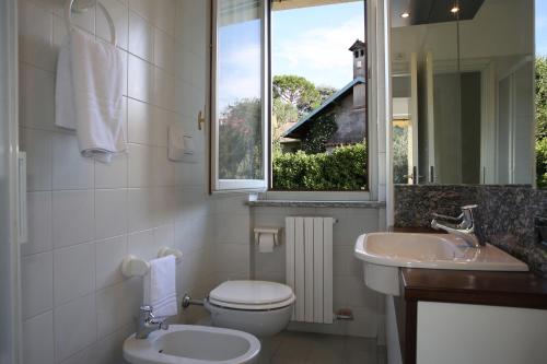 un bagno con un water, un lavandino e una finestra di Tasso 10 a Bellagio