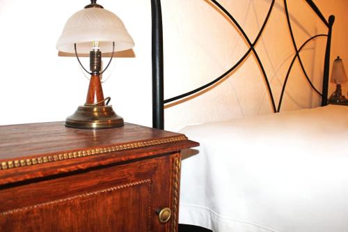 a lamp on top of a dresser next to a bed at Victoria's Apartment in Thessaloniki