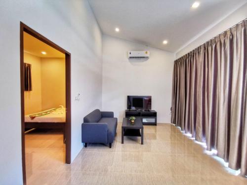 a living room with a blue chair and a television at Diamond Pool Villa@Samui in Koh Samui 