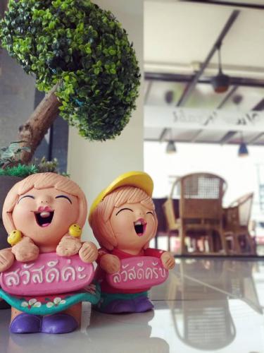 two figurines of two girls sitting next to a tree at Krabi River View Hotel in Krabi town